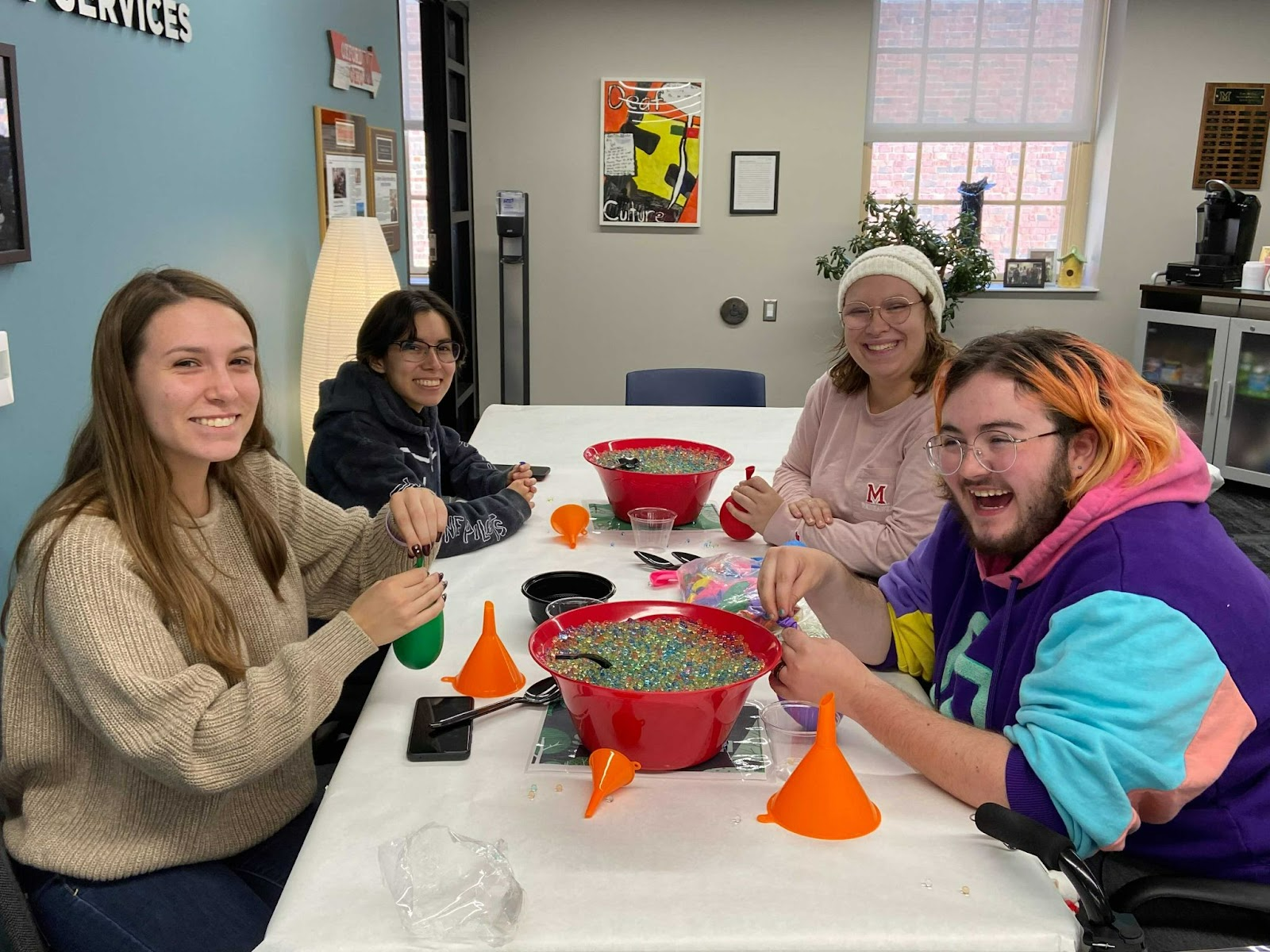 4 students in the Miller Center, working on an orbeez craft