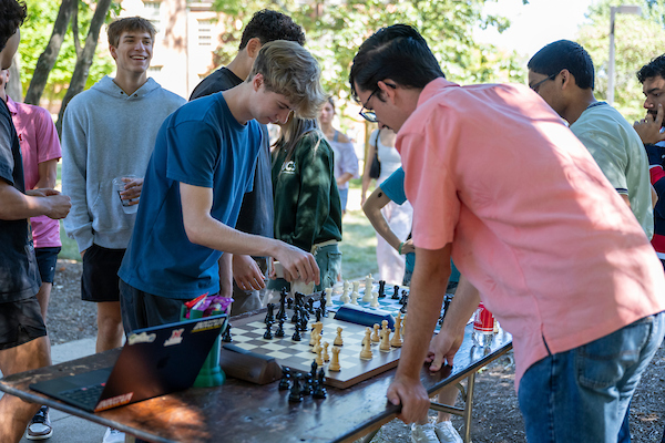 Two students playing chess at a Mega Fair table