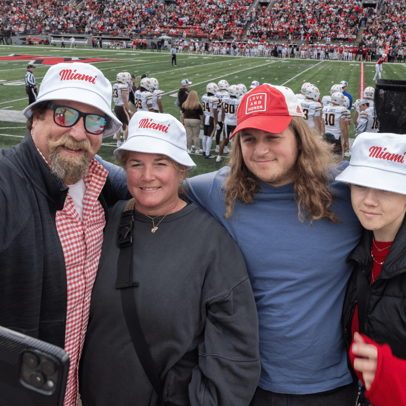 Family of four taking a selfie at a Miami football game