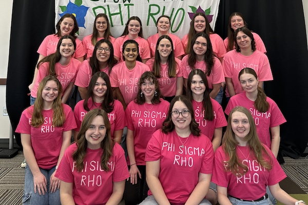Group of about 20 women in pink shirts that read phi sigma rho