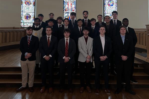 group of about 15 men in suits posing in Kumler Chapel. 