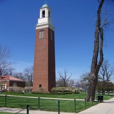 Tall brick tower with an opening for a large bell toward the top.