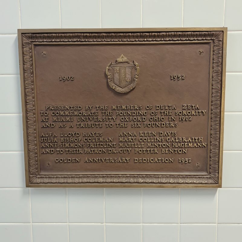 Plaque that reads 1902 1952. Presented by the members of Delta Zeta to commemorate the founding of the sorority at Miami University Oxford Ohio in 1902 and as a tribute to the six founders, Alpha Lloyd Hayes, Julia Bishop Coleman, Anne Simmons Friedline, Anna Keen Davis, Mary Collins Galbraith, Mabelle Minton Hagemann, and to their patron Dr. Guy Potter Benton. Golden Anniversary Dedication 1952.
