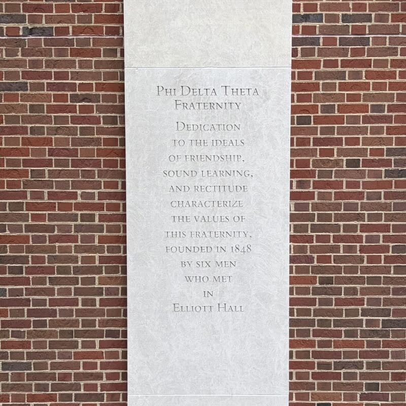Concrete column with words etched: Phi Delta Theta Fraternity Dedication to the ideals of friendship, sound learning, and rectitude characterize the values of this fraternity, founded in 1848 by six men who met in Elliott Hall. 