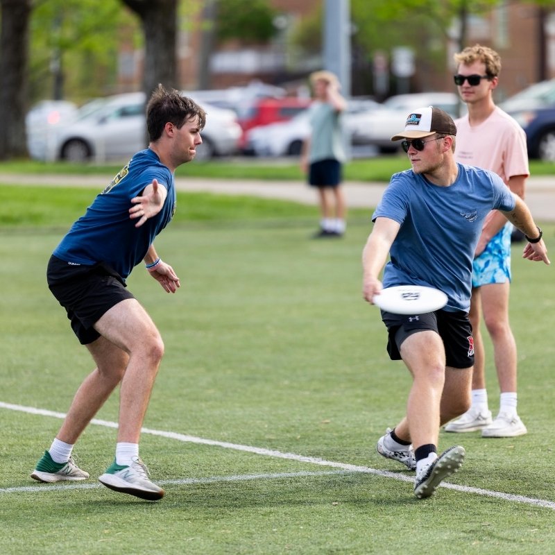 Students playing frisbee on a field
