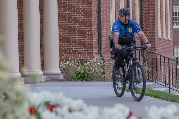 police officer riding bike on campus