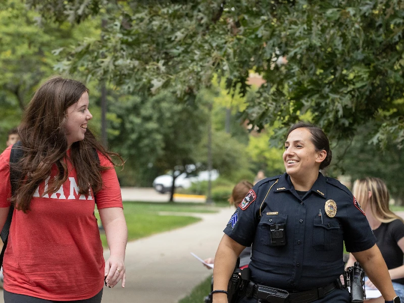 police officer walking with student on campus