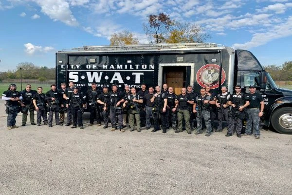 photo of oxford and miami swat team in front of swat vehicle