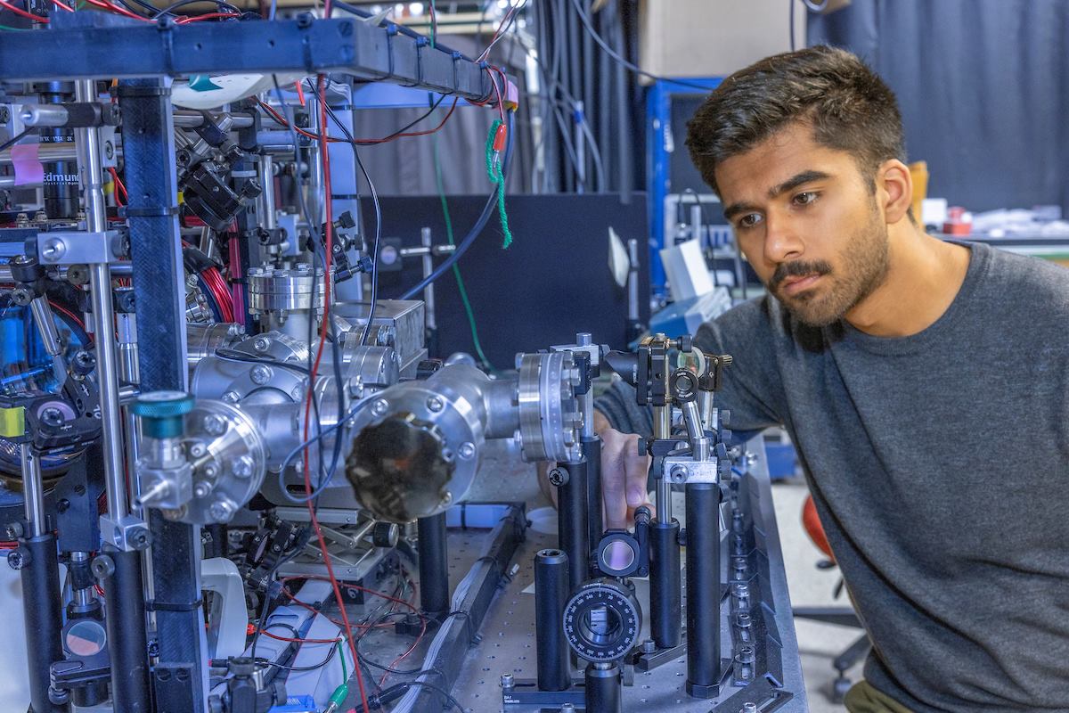 Chanakya Pandya working in a physics laboratory with some machinery