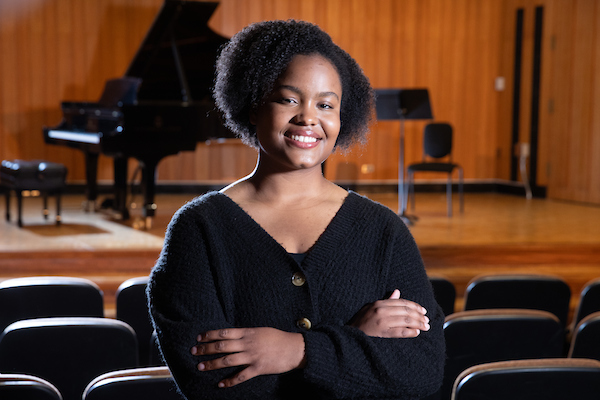 Jeysla Rosario Santos standing in front of the recital stage with a grand piano