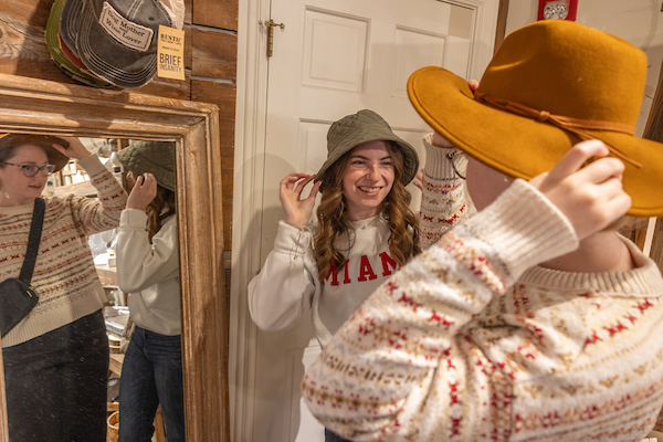 Katie Gabe trying on hats with her friend at one of the shops in Uptown Oxford, Ohio
