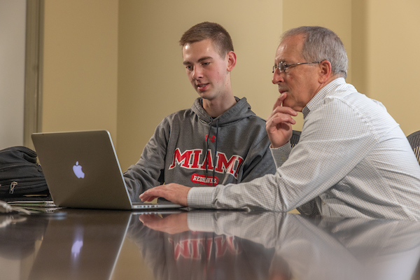 Levi Grimm in a classroom working with his professor