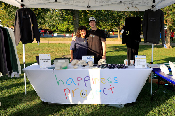 Mike Jones at a booth selling Happiness Project merch.