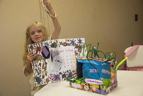 A saakaciweeta student proudly displaying her myaamia projects from the summer youth programs in Fort Wayne, Indiana