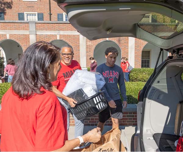 Parents help their son move in to a Miami residence hall