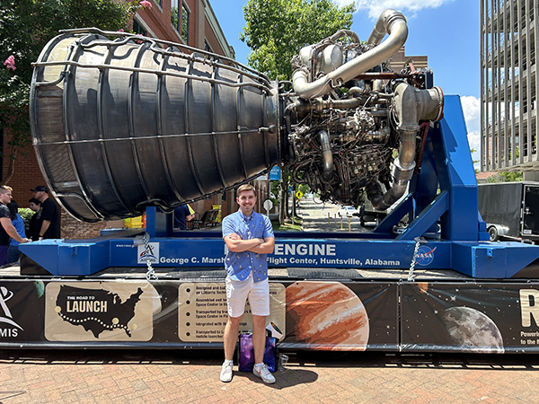 Bradley Gartner stands in front of an engine