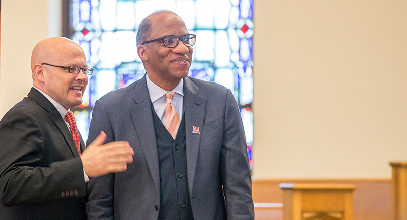 President Crawford stand with alumni author Wil Haygood in Kumler Chapel