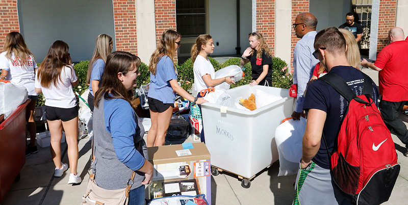 Incoming first-year students work with Miami volunteers to move in their belongings.