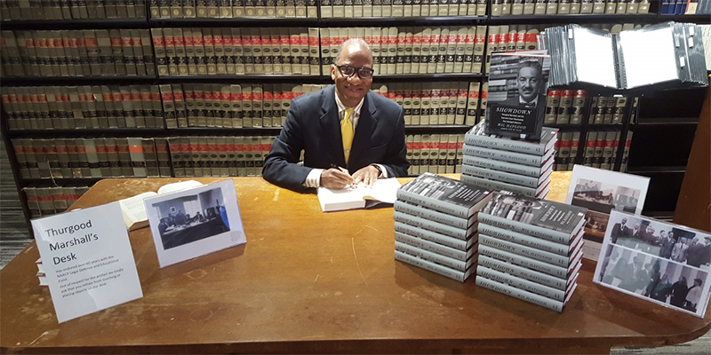 Author Wil Haygood sits at the desk of Thurgood Marshall.