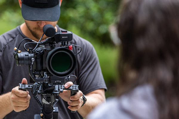 closeup of a man looking into a large film camera