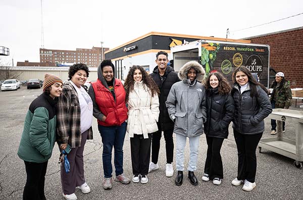 8 students pose in front of the la soupe truck on a winter day