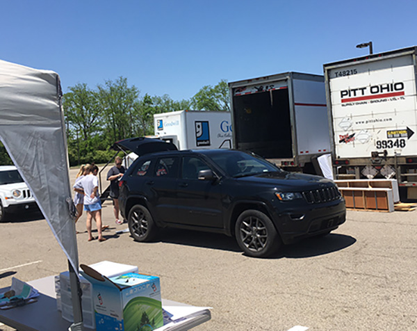 Chestnut Fields parking lots with 2 trucks and a black SUV being unloaded with items for ShareFest