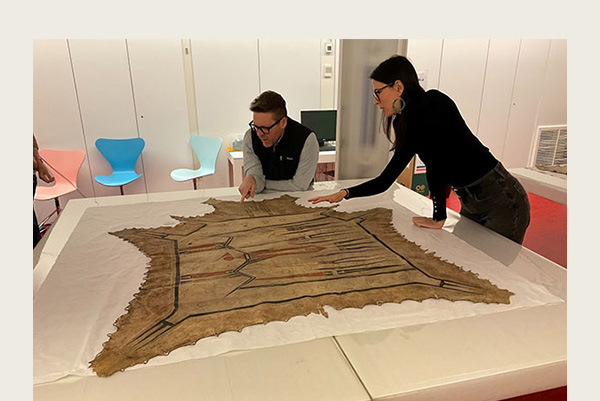 From left to right, Scott Shoemaker (Miami Tribe of Oklahoma) and Elizabeth Ellis (Peoria Tribe of Indians of Oklahoma) visit with a Ciinkwia minohsaya ‘Thunder Being robe’ at the Musée du quai Branly-Jacques Chirac in April 2023. Photo by George Ironstrack, Myaamia Center.