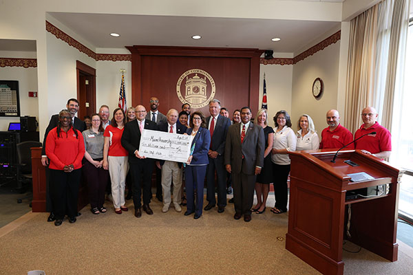 Members of Miami University and the Butler County Board of Commissioners pose with a symbolic check 