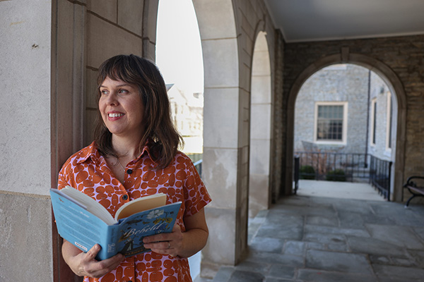 TaraShea Nesbit holds her book Beheld in the courtyard of Bachelor Hall