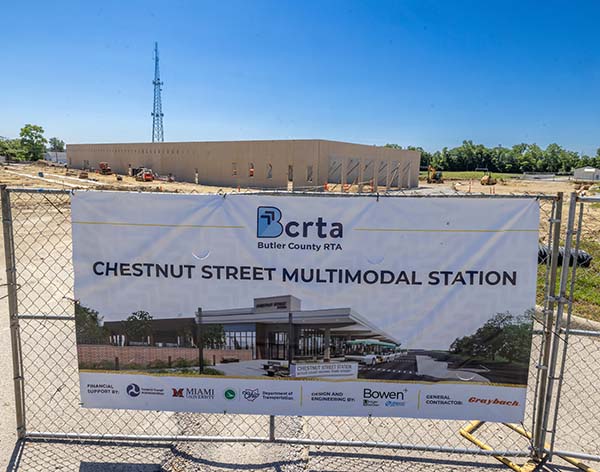 Chestnut Street Station construction site and a fence with a large banner and rendering of the  design for the multimodal transportation hub