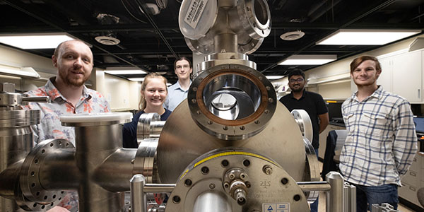 Perry Corbett, assistant professor of Physics, left, stands with students Sara McGinnis, Carter Wade, Lakshan Don Manuwelge Don, and Nate Price around the newly donated ultra-high vacuum scanning tunneling microscope.