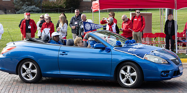 A blue car representing Western College for Women participates in the 2022 Miami University Homecoming Parade