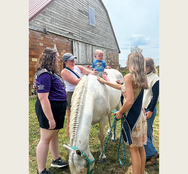 This was taken at the Logan County Fair. To Amberly Szczerbiak's left is 2024 Highland County Fair Queen Alexis West, and to her right is 2025 Logan County Fair Queen Kayley Knox. "We helped a sweet family place their baby on a pony for the first time," she said. (Photo courtesy of Amberly Szczerbiak)