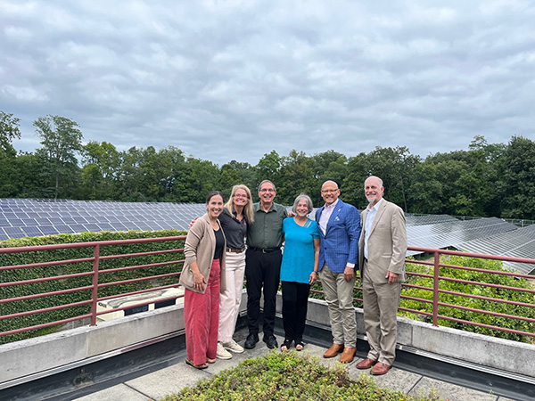 sharon and graham Mitchell and the crawfords on the geothermal plant roof with solar field in background
