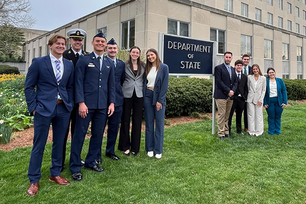Students pose with Department of State sign