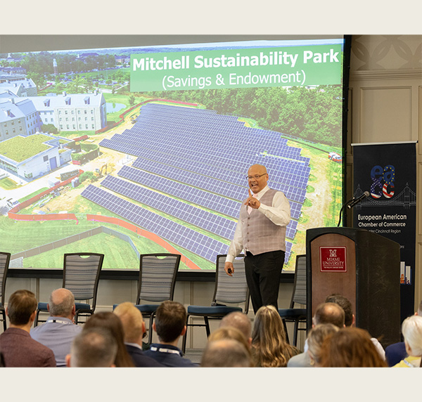 Greg Crawford talks to the audience in front of a slide showing the Mitchell Sustainability Park 