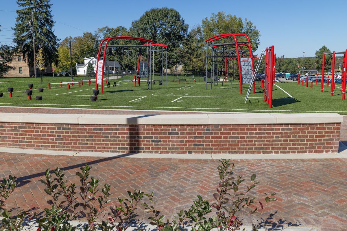 Outdoor Exercise equipment near Millett and a llow brick wall and brick plaza area