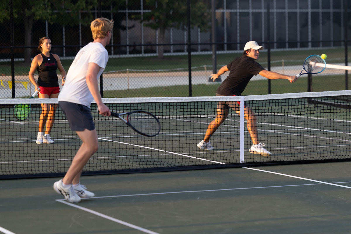 Several students play tennis on the outdoor court near Millett Hall 