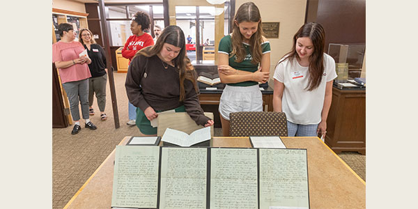Miami University students look at materials from the Wells Hall time capsule during a recent event at King Library.