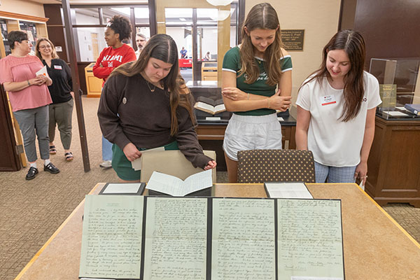Miami University students look at materials from the Wells Hall time capsule during a recent event at King Library.