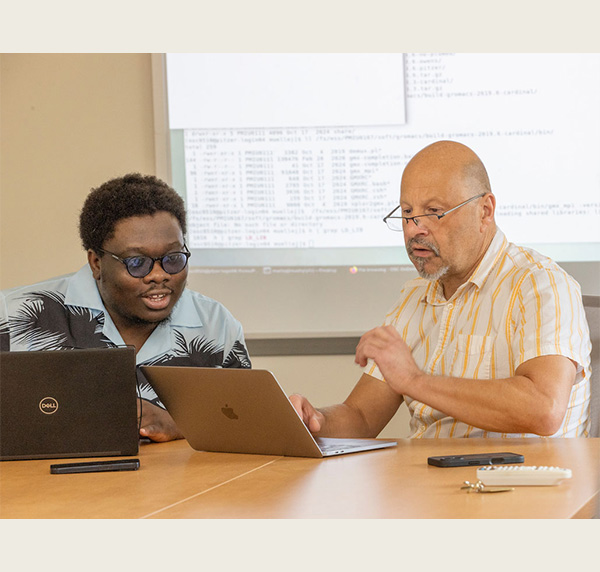 Jens Mueller (right) and doctoral student in Chemistry and Biochemistry Ikponwmosa Obaseki (left) discuss computational workflows on OSCs Ascend and Pitzer clusters