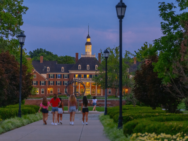 students walking around campus on a summer night