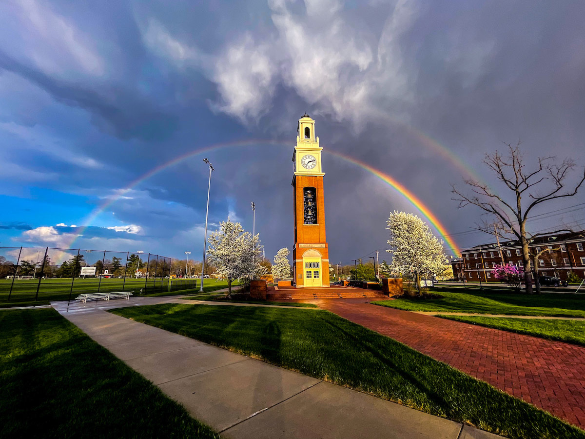 A stunning wide angle view of an entire rainbow centered over Pulley Tower with storm clouds receding