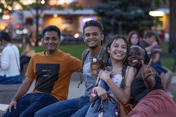 Four students smile for the camera at a festival.