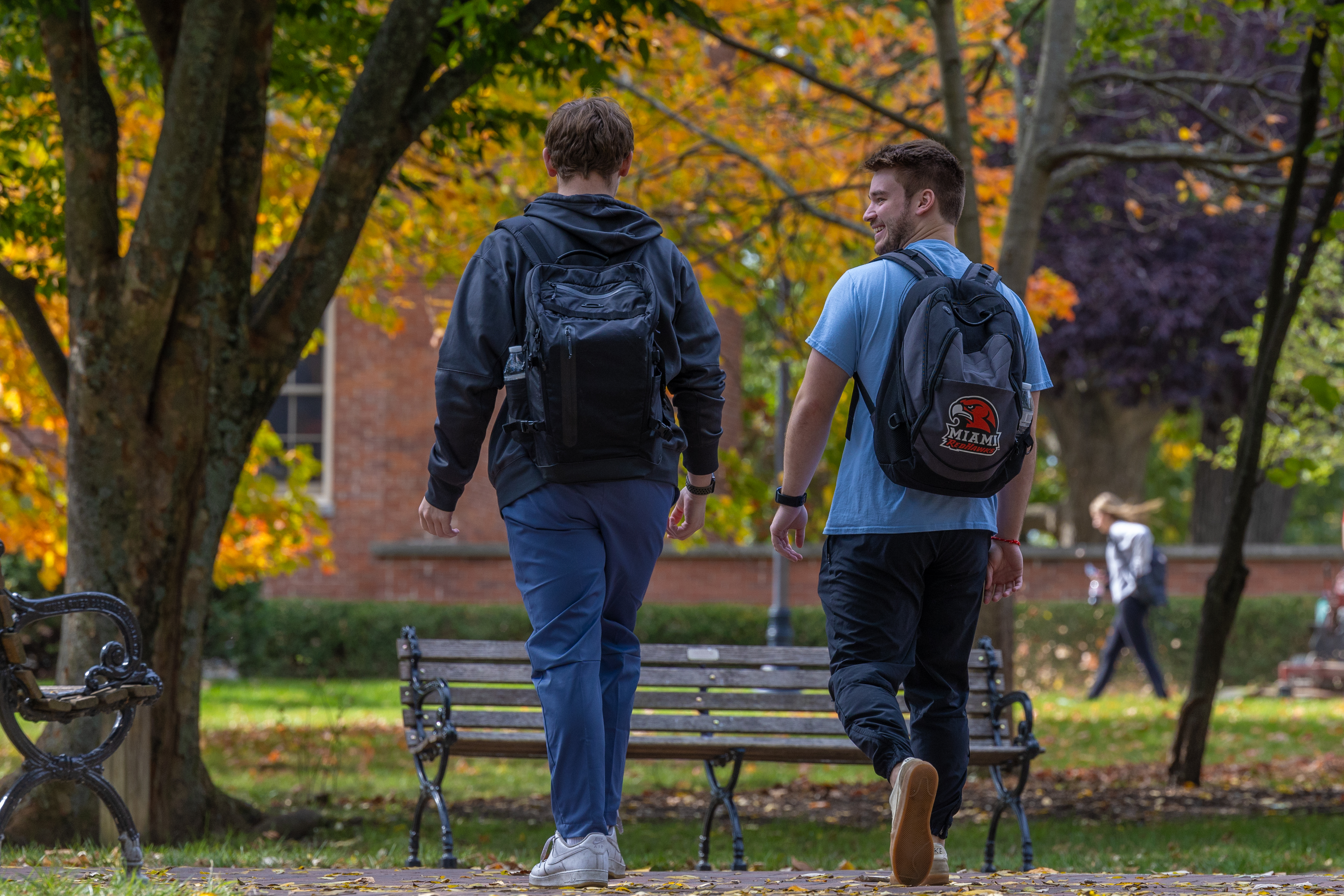 Two students speak with a person at a networking event.