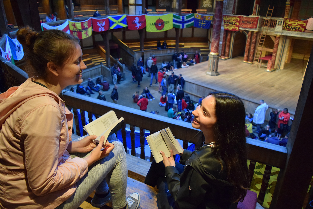 Two students read books overlooking a festival in London.