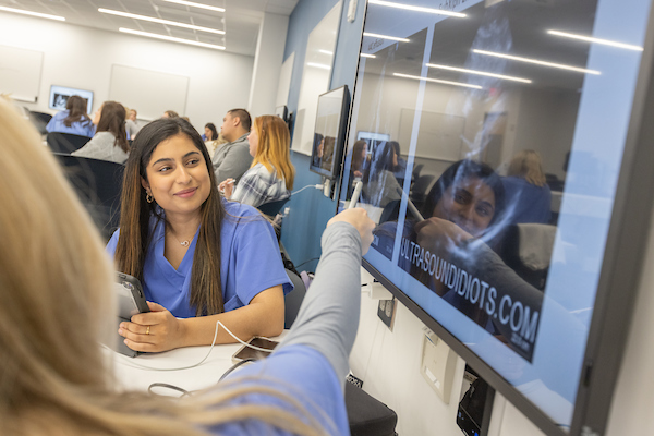 A student looks at a wall monitor during a nursing class.
