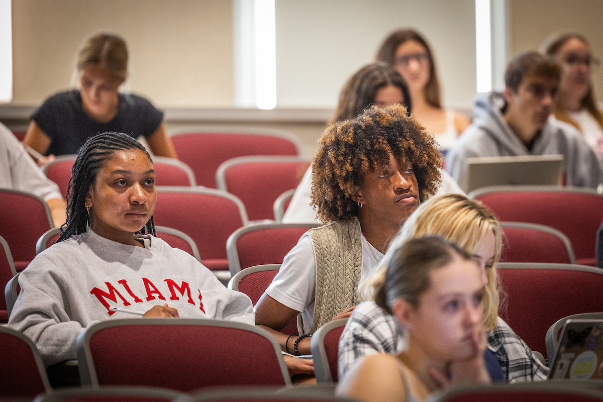 Two students listen to a lecture.