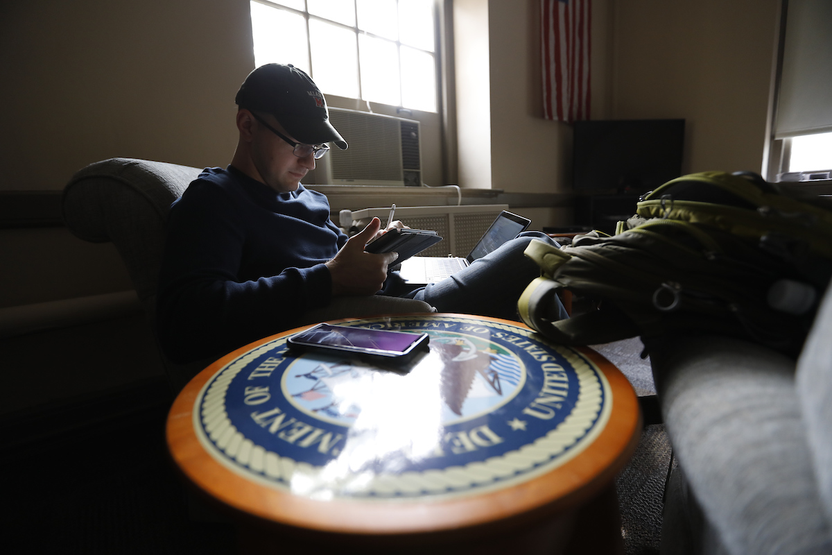 A student veteran studies in an armchair in the Student Veterans Center.