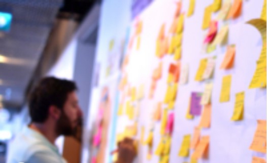 A man organizing sticky notes using Agile methodologies